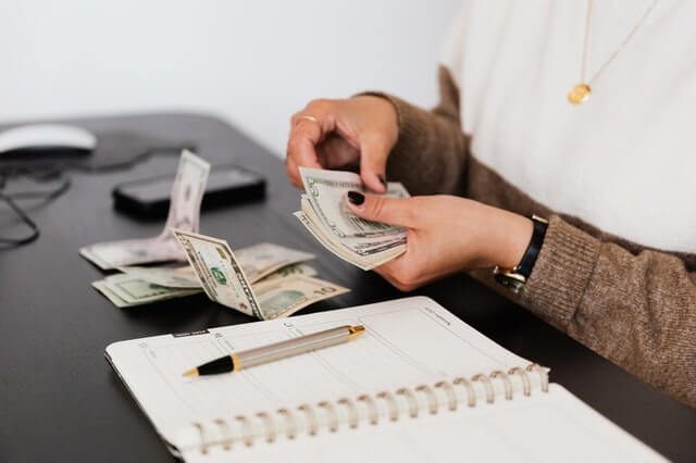 crop-payroll-clerk-counting-money-while-sitting-at-table crop-payroll-clerk-counting-money-while-sitting-at-table